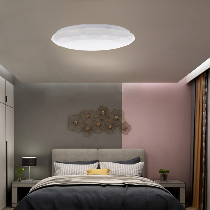 Corp LED rotund montat pe tavan intr-un dormitor luminos
